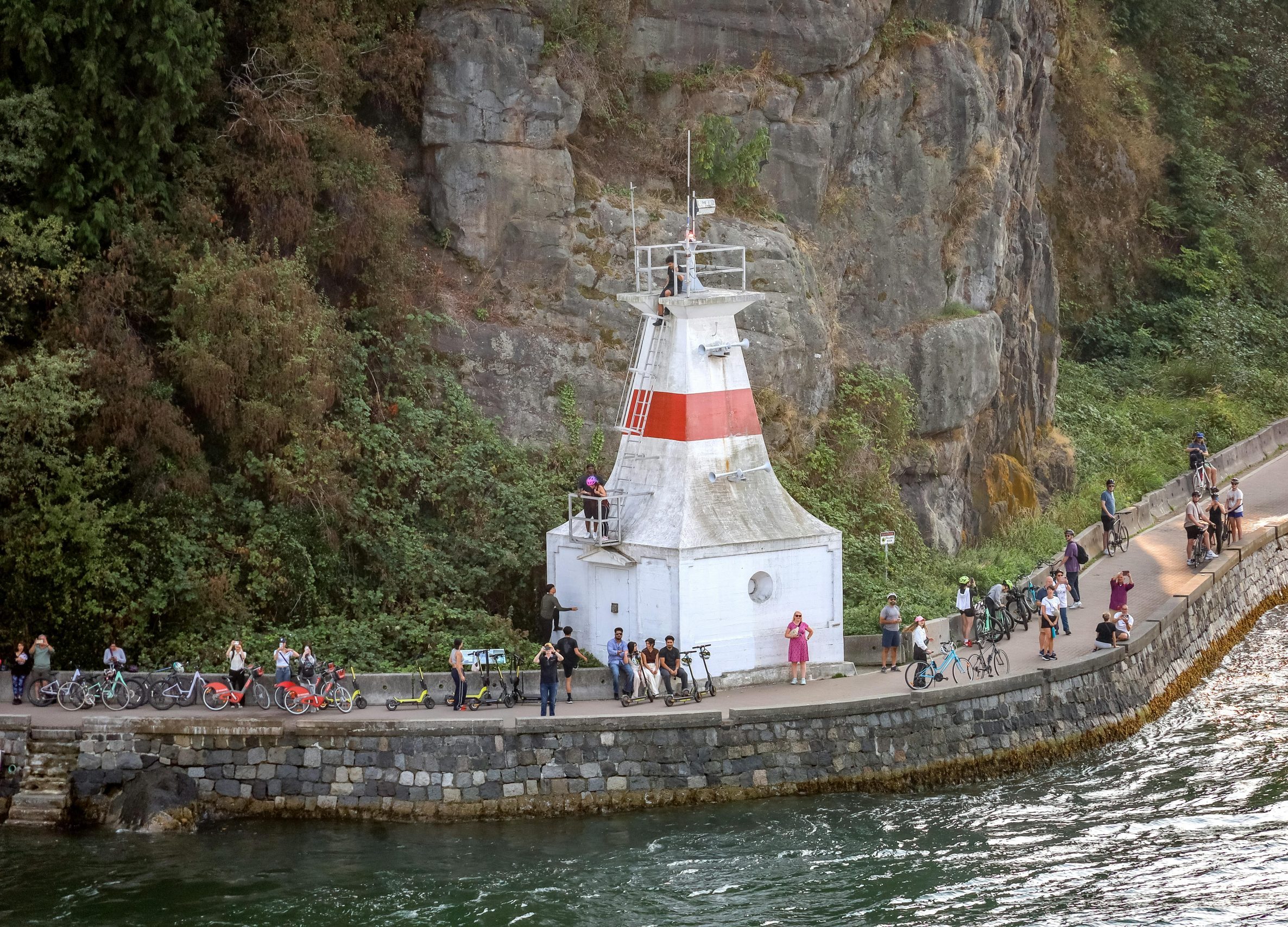 Scenic view of Prospect Point Lighthouse with visitors on the Stanley Park seawall, Vancouver.
